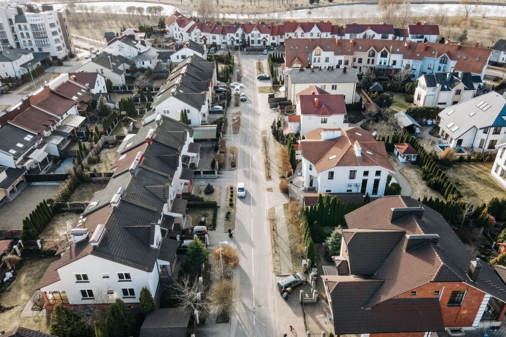 Aerial view of a suburban neighborhood with houses, streets, and cars.